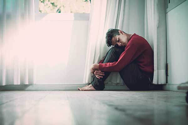 Man sitting on floor not feeling mentally well